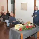 Palestra em sala com público e oradores.