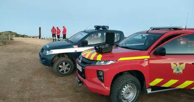 Veículos de emergência e socorristas em terreno.