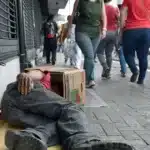 Pessoa desabrigada dormindo na rua durante o dia.