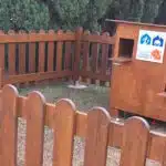 Casa para cães e gatos com cercado de madeira.