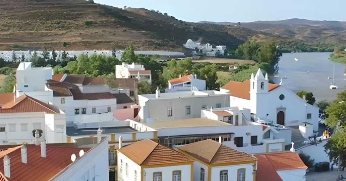 Vila portuguesa com igreja e rio.