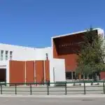 Fachada de escola moderna com bicicletas estacionadas.