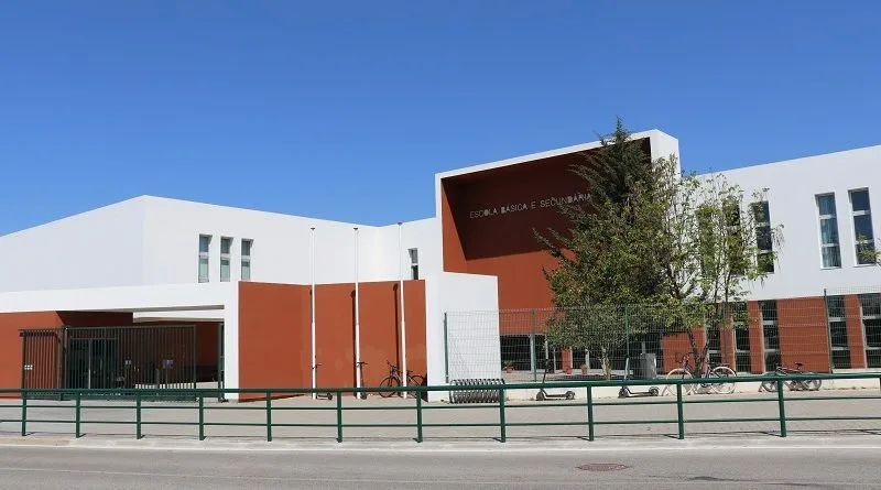 Fachada de escola moderna com bicicletas estacionadas.