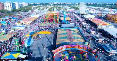 Feira popular lotada com diversões e roda gigante.