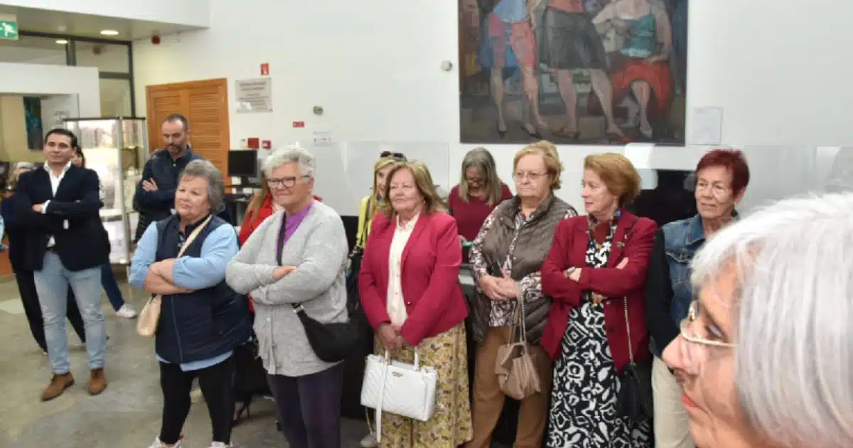 Grupo de idosos visitando exposição de arte.