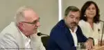 Três pessoas participando em painel de discussão.