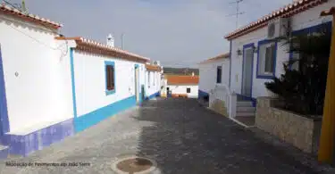 Rua tradicional portuguesa com casas brancas e azuis.