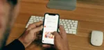 man holding phone while leaning on table